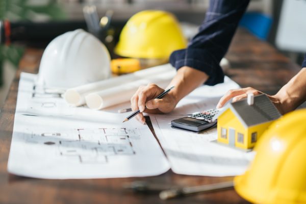 Cropped shot of Professional architect working at his desk, measuring and estimating the house project.